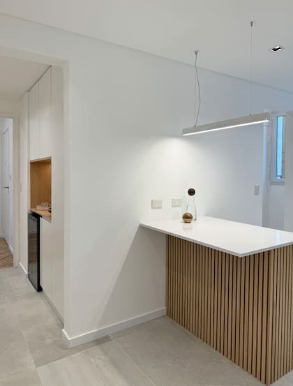 Varillado en isla (diseñado y ejecutado por el estudio, madera Roble Americano). Iluminación (Flow suspendido, Eurolamp).