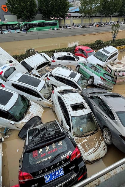Varios autos amontonados después de que las fuertes lluvias azotaran la ciudad de Zhengzhou, en Henan