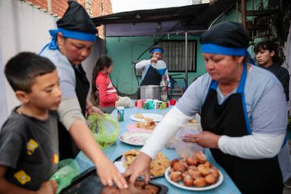 Varios chicos reciben comida en el merendero Luz y Esperanza, en Esteban Echeverría