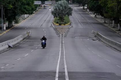 Varios ciudadanos intentan bloquear una calle en protesta por los resultados oficiales el día después de las elecciones presidenciales mientras agentes de la Guardia Nacional crean una línea de contención detrás de ellos en Caracas, Venezuela, el lunes 29 de julio de 2024. (AP Foto/Cristian Hernández)