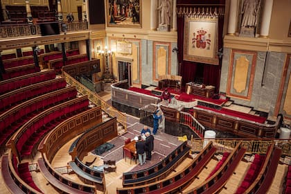 Varios empleados preparan el estrado del hemiciclo para la jura de la Constitución la Princesa de Asturias, en el Congreso de los Diputados, a 24 de octubre de 2023, en Madrid (España).