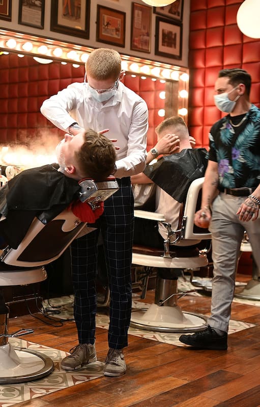 Varios jóvenes se cortan el cabello en "Barber Barber Barbers" en Liverpool, Inglaterra