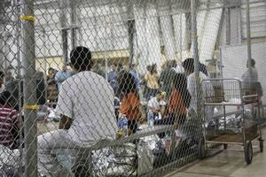 Varios menores esperan sentados en el centro de detención de inmigrantes ilegales en McAllen, en el estado de Texas