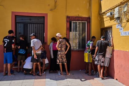 Varios migrantes, algunos de ellos menores no acompañados, que cruzaron desde Marruecos hacia España, escriben su información de contacto para dársela a una asociación vecinal en el enclave español de Ceuta