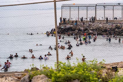 Varios migrantes tratan de cruzar desde Marruecos hacia el enclave español de Ceuta, el viernes 31 de julio de 2026. (AP Foto/Antonio Sempere)