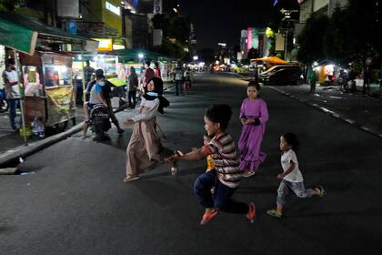 Varios niños juegan en una calle el lunes 21 de junio de 2021, en Yakarta, Indonesia. (AP Foto/Dita Alangkara)