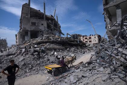 Varios Palestinos rescatan lo que pueden de la destrucción dejada por las tropas israelíes en Khan Younis, en el sur de la Franja de Gaza, el 8 de abril de 2024. (AP Foto/Fatima Shbair, Archivo)