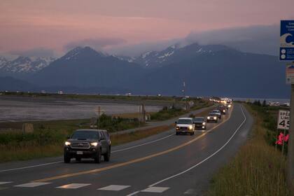 Varios pobladores salen en sus vehículos de Homer Spit, en Homer, Alaska, el miércoles 28 de julio de 2021, debido a una alerta de tsunami tras un sismo de magnitud 8,2. (Sarah Knapp/Homer News vía AP)