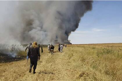Varios sirios tratan de extinguir un incendio en un campo de cultivo en Jaabar, en la provincia de Raqqa