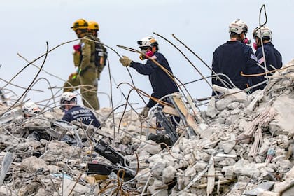 Varios socorristas revisan los escombros del edificio residencial Champlain Towers South