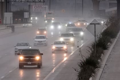 Varios vehículos se abren paso en una autopista empapada por la lluvia en Dallas, el jueves 26 de diciembre de 2024. (AP Foto/LM Otero)