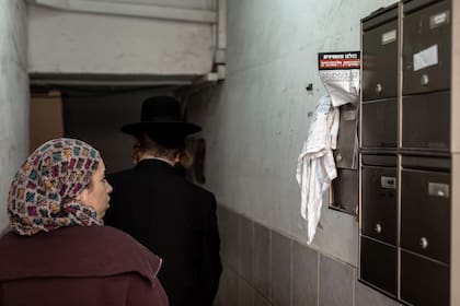 Vecinos de la ciudad de Bnei Brak pasan junto a un panfleto pidiendo el respaldo a las víctimas potenciales de Chaim Walder