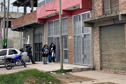 Vecinos esperan para comprar en la carnicería ubicada a pocos metros del supermercado chino atacado anoche.