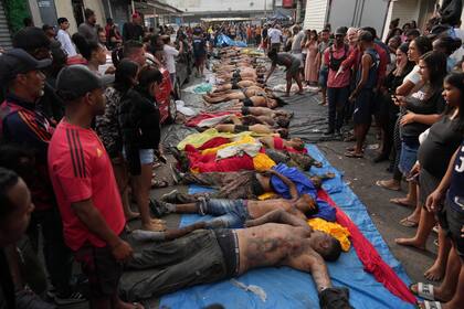 Vecinos identifican a sus familiares y amigos tras el operativo en Río
(AP Photo/Silvia Izquierdo)