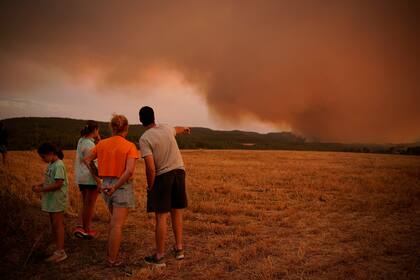 Vecinos mirando a un incendio forestal cerca de Tarragona, en la región nororiental de Cataluña, España