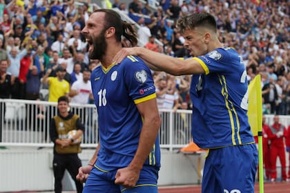 Vedad Muriqi celebra su gol: Edon Zhegrova se cuelga de él.
