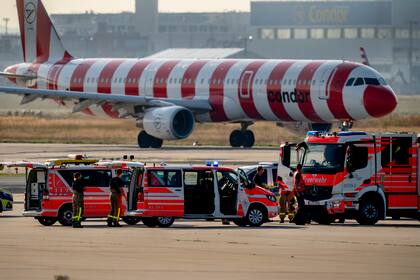 Vehículos de emergencias se ven en una pista del aeropuerto de Fráncfort, Alemania, el jueves 25 de julio de 2024 después de que varios activistas climáticos se pegaran al suelo y bloquearan el tráfico aéreo durante varias horas. (AP Foto/Michael Probst)