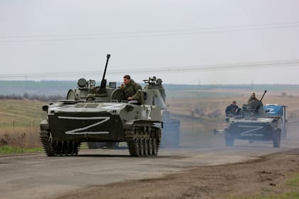 Vehículos militares rusos se mueven en una carretera en una zona controlada por las fuerzas separatistas respaldadas por Rusia cerca de Mariupol, Ucrania, el lunes 18 de abril de 2022