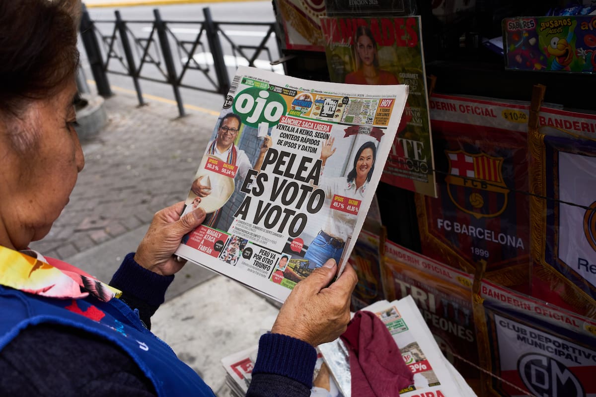 Vendedora de periódicos lee la portada de un diario que dice en español: "La pelea es voto a voto" en Lima, Perú, el lunes 8 de junio de 2026, un día después de la segunda vuelta de las elecciones presidenciales. (Foto AP/Rodrigo Abd)