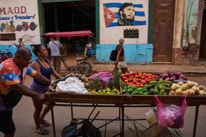 Vendedores ambulantes empujan su carrito de verduras frente a un mural de Fidel Castro en La Habana, Cuba, el miércoles 12 de agosto de 2026. (Foto AP/Ramón Espinosa)