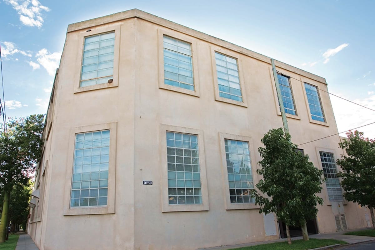 Ventanas espejadas y fachada en rosa claro, así quedó por fuera la antigua fábrica de remeras