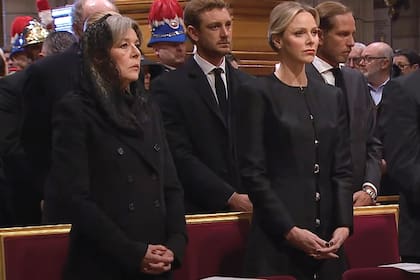 Vestida de luto y con
mantilla de encaje,
Carolina estuvo junto la princesa
Charlene. Atrás vemos
a sus hijos, Pierre y
Andrea Casiraghi.