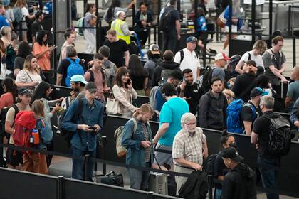 Viajeros hacen largas filas en un punto de revisión, el martes 5 de julio de 2022, en el Aeropuerto Internacional de Denver. (AP Foto/David Zalubowski)