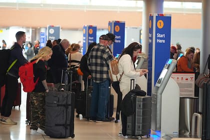Viajeros usan módulos de check in para vuelos de Southwest Airlines en el Aeropuerto Internacional de Denver, el martes 26 de noviembre de 2024, en Denver. (AP Foto/David Zalubowski)