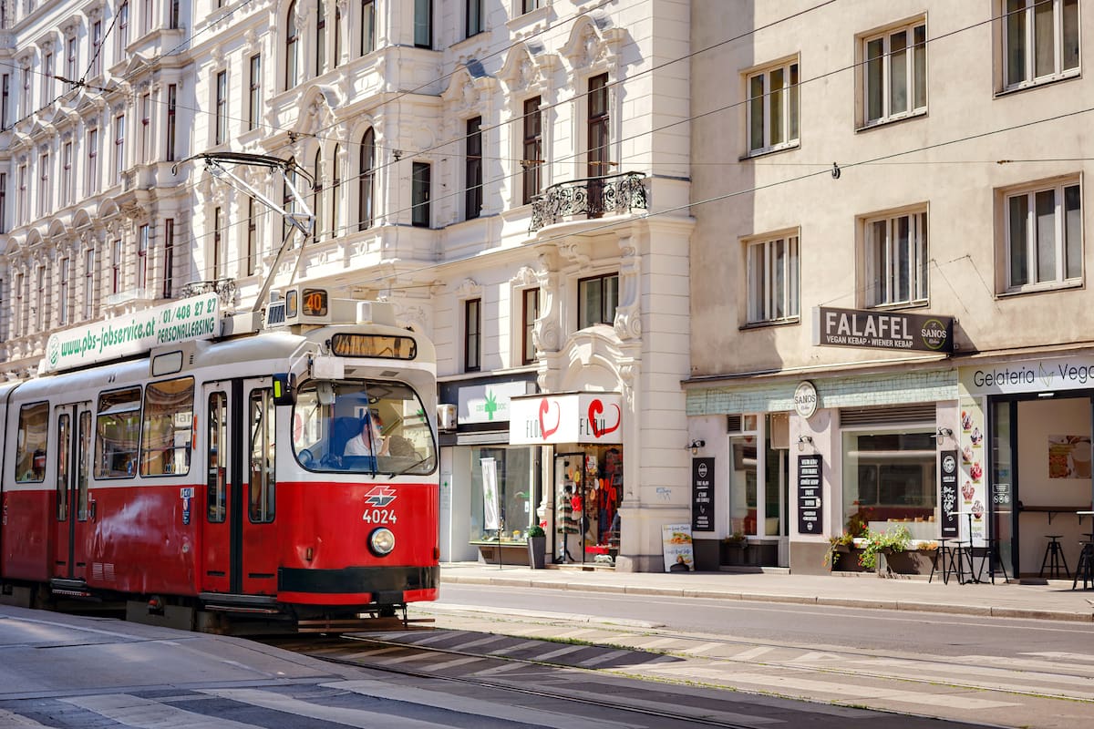 Vienna, Austria - August 11, 2022 : public transport in the city. Tram goes by the street of Vienna. Vienna is capital and largest city of Austria. Red retro tram Vienna Ring Tram at train station