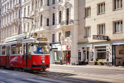 Vienna, Austria - August 11, 2022 : public transport in the city. Tram goes by the street of Vienna. Vienna is capital and largest city of Austria. Red retro tram Vienna Ring Tram at train station