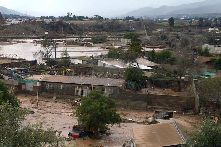 View of a flooded rural area near the outlet of a river in Coquimbo region, Chile, on July 21, 2026, following severe weather conditions. Heavy rains in Chile have killed at least 13 people and left more than 60,000 others cut off due to washed out roads, government officials said in a report on July 21, 2026, as the recovery effort focused on restoring basic services. (Photo by Armando Gonzalez / AFP)