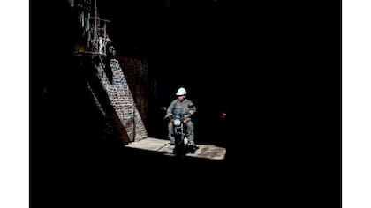 Un obrero de construcción anda en moto a través de la Villa