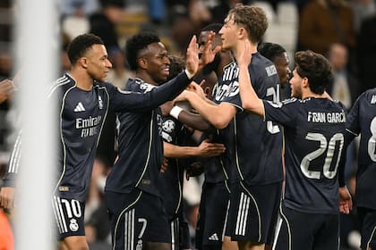 Vinicius Jr. (7) recibe el saludo de sus compañeros: el atacante anotó los dos goles en el triunfo 2 a 1 de Real Madrid sobre Manchester City en el desquite por los octavos de final de la Champions League