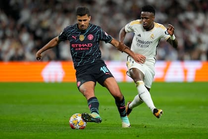 Vinicius Junior (derecha) del Real Madrid lucha por el balón con Rodri del Manchester City en los cuartos de final de la Champions League 2024; el volante español le ganó la pulseada final por el Balón de Oro 2024 al delantero brasileño