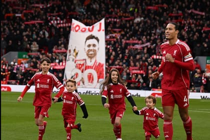 Virgil van Dijk sale a la cancha junto a dos de los hijos de Diogo Jota —Dinis y Duarte— como “mascotas” antes del partido entre los clubes ingleses de su padre