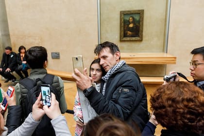Visitantes al Louvre se sacan una selfie en frente de la Mona Lisa, en París, Francia