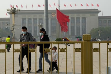 Visitantes con barbijo caminan en la Plaza Tiananmen previo al Congreso del Partido Comunista Chino (PCCh)
