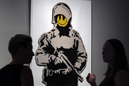 Visitantes del Museo del Arte Prohibido de Barcelona frente a la obra "Smiling Copper", de Banksy