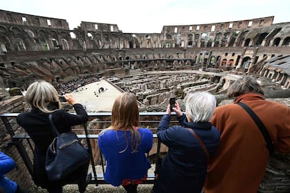 Visitantes toman fotografías a cantantes y músicos de la academia Santa Cecilia que actúan en el emblemático Coliseo de Roma que reabrió en medio de una flexibilización de las restricciones al coronavirus