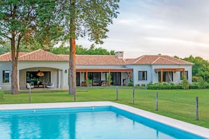 Vista de la casa que demuestra la disposición de los espacios exteriores: a la izquierda, el quincho que se conecta con la cocina; a la derecha, la galería central conectada al living. En el extremo derecho, un espacio con hamaca conectado con la suite principal.