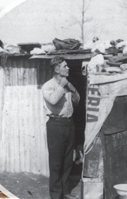 Vista de la Villa 1-11-14 en el Bajo Flores, Buenos Aires. (Prensa Obrera). Un joven se arregla afuera de su vivienda (Archivo General de la Nación)