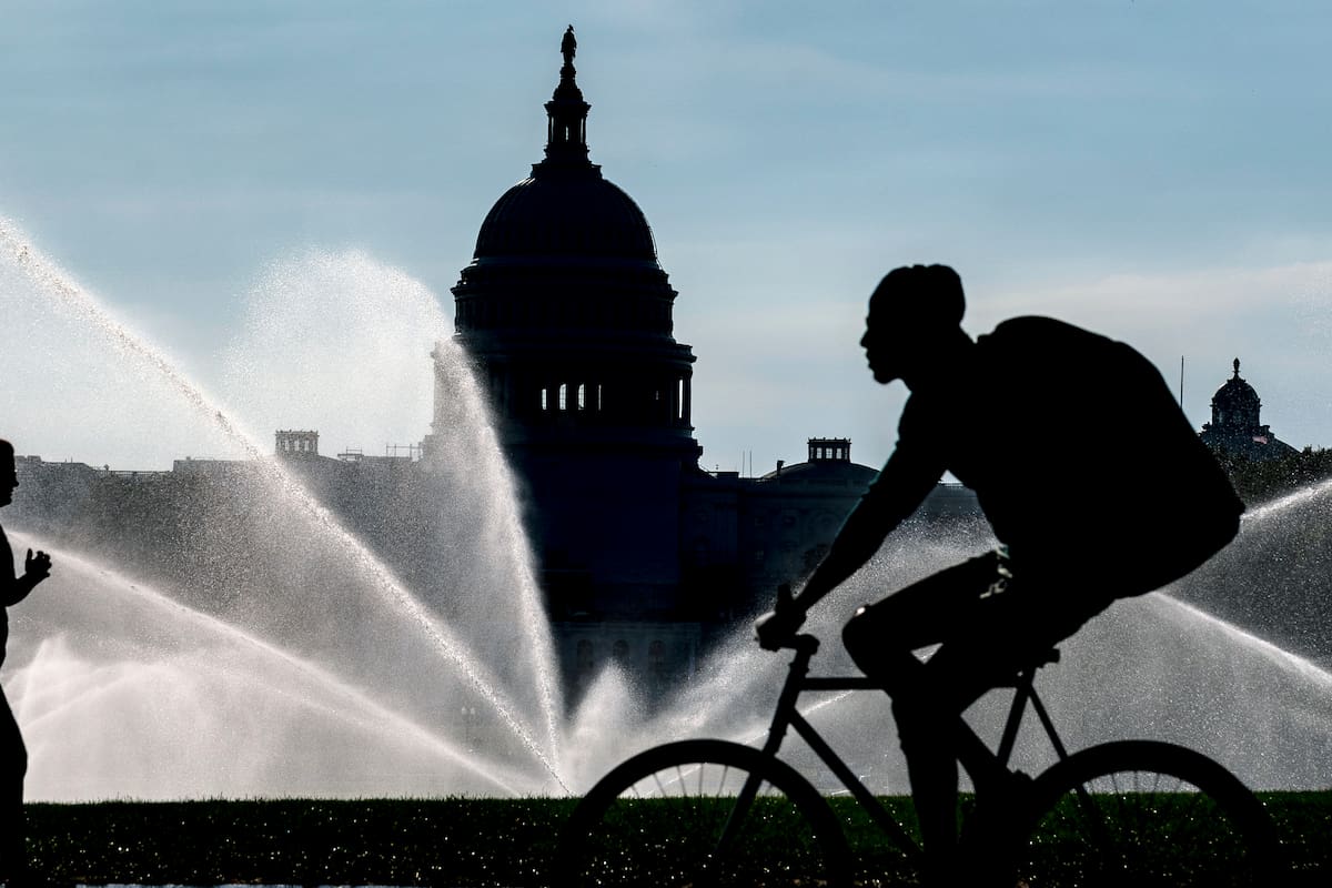 Vista del Capitolio y de aspersores de agua que empapan el National Mall en una calurosa mañana de verano en Washington (AP Foto/J. Scott Applewhite)