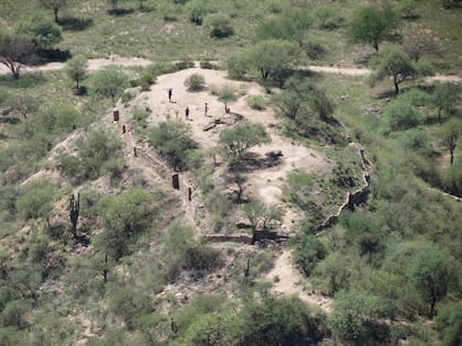 Vista del cerro ceremonial del oeste (Templo de la Luna ) con muro perimetral en zig zag y una roca sagrada en el centro.