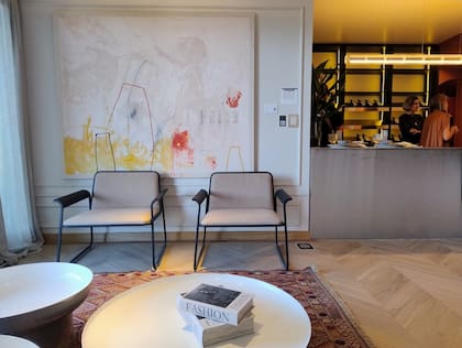 Vista desde el living con sillas de Ascolta, mesas 'Pluvial' (Federico Churba) sobre alfombra de Desde Asia. Como gran fondo, la obra de Santiago García (Diderot.art).