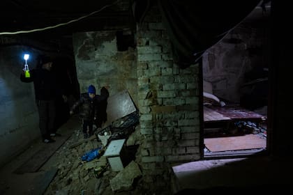 Vlad (6 años) y su papá, en el sótano donde pasaron más de un mes; en ese tiempo de frío y oscuridad perdió a su mamá
