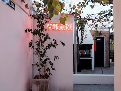 Volare en luces de neón, al lado del pequeño patio donde está la parra, y antecediendo el salón principal.