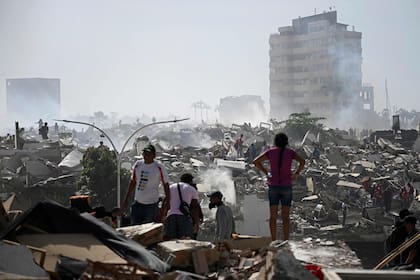 Voluntarios buscan posibles víctimas en un edificio derrumbado tras los terremotos gemelos en Caraballeda, estado de La Guaira