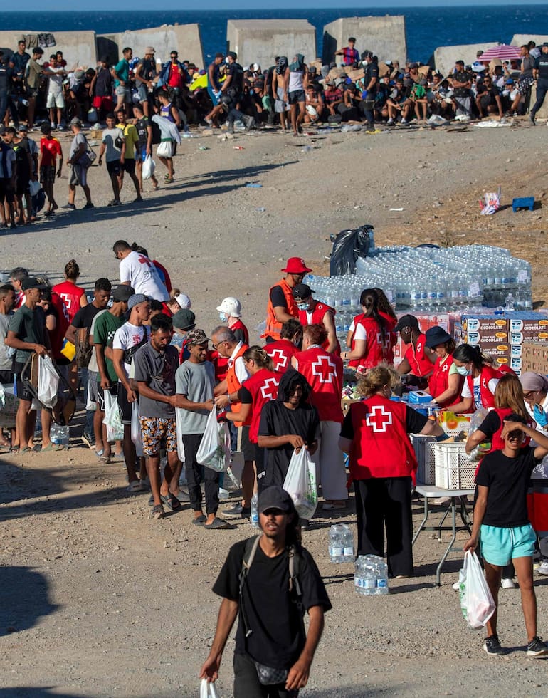 Voluntarios de la Cruz Roja distribuyen alimentos entre los inmigrantes en Ceuta