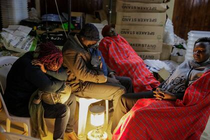 Voluntarios electorales se toman un descanso durante el conteo de los votos en Eldoret, Kenia, el miércoles 10 de agosto de 2022. Los kenianos esperaban el martes a conocer los resultados de unas elecciones presidenciales ajustadas pero tranquilas, con una participación menor de la habitual. (AP Foto/Brian Inganga)c