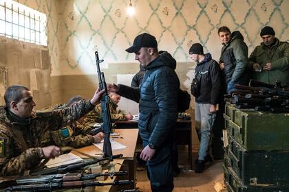 Voluntarios reciben armas en un centro de almacenamiento de armamento, el 25 de febrero de 2022, en Fastiv, Ucrania.